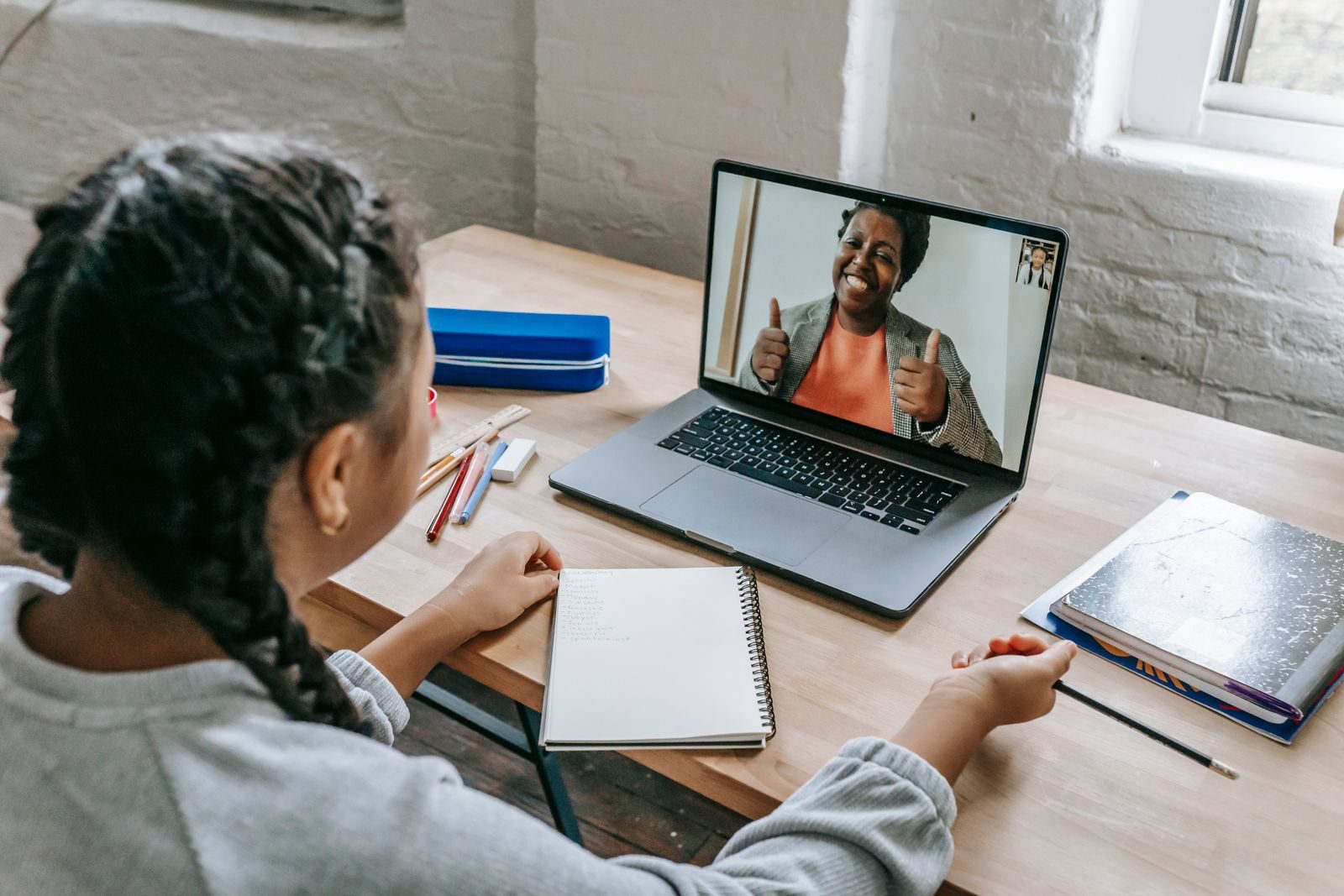 A learner following a live online lesson at a home study desk